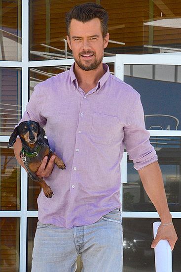 Josh Duhamel carrying his Dachshund on his side