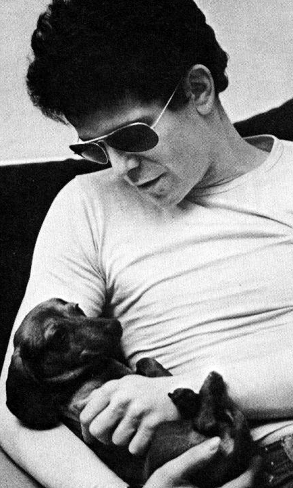 Lou Reed holding his Dachshund on his side