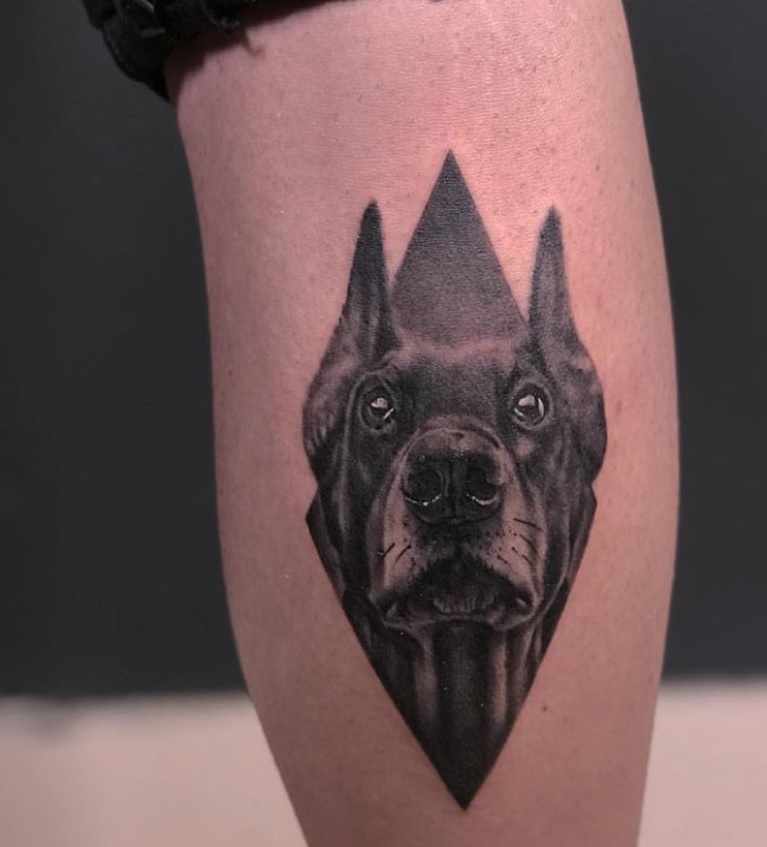 face of Doberman Pinscher in a diamond tattoo on the leg