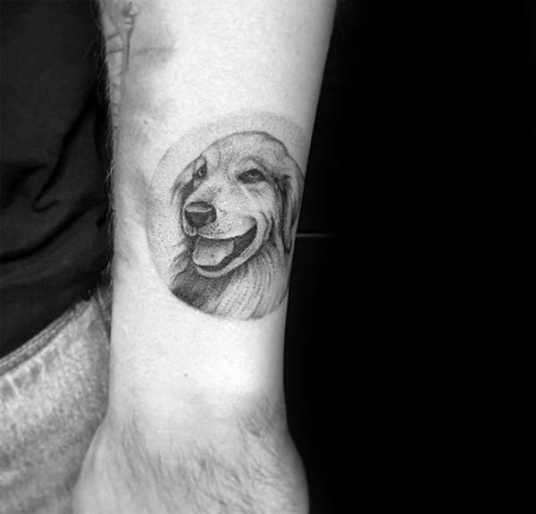 smiling Golden Retriever inside a faded circle tattoo on the arm