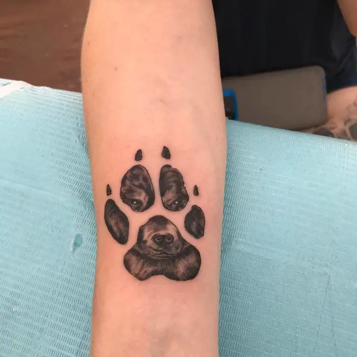 paw print with face of a dog tattoo on wrist