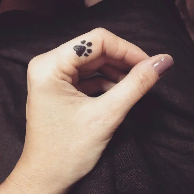small paw print tattoo on the side of the pointing finger