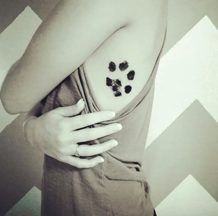 paw print tattoo on the side of the body
