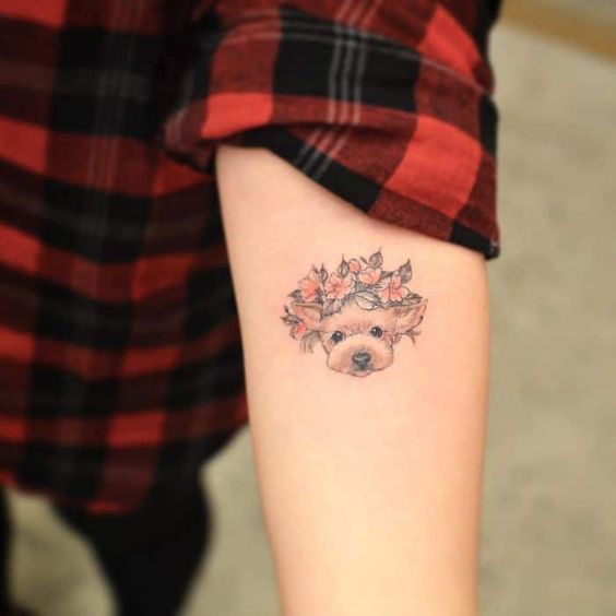 a yorkie with flower crown tattoo on the forearm