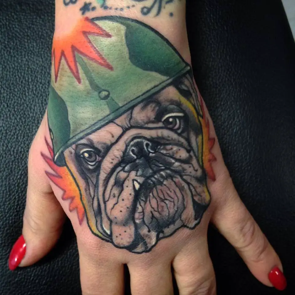 face of an English Bulldog wearing an army cap tattoo on hand