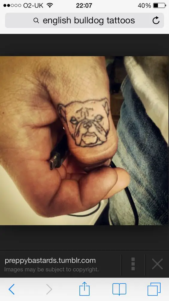 outline face of an English Bulldog tattoo on the thumb finger