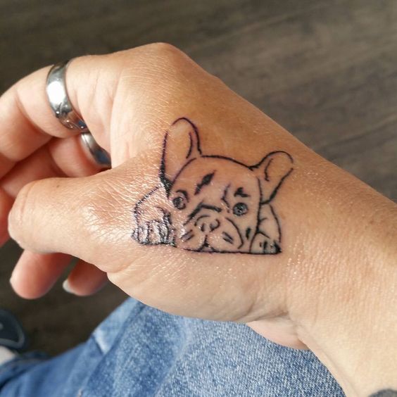 outline of lying down French Bulldog Tattoo on the hand