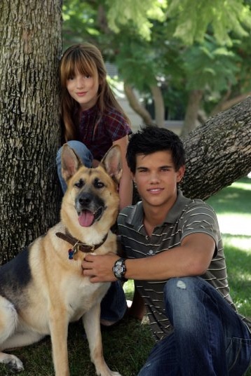#4 Bella Thorne and Taylor Lautner with their German Shepherd sitting on the grass