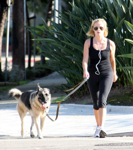 Reese Witherspoon walking in the street with her German Shepherd