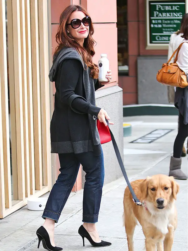 Kyle Richards walking in the street with her Golden Retriever