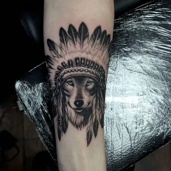 black and gray Husky with blue eyes wearing an Indian Hat tattoo on the forearm