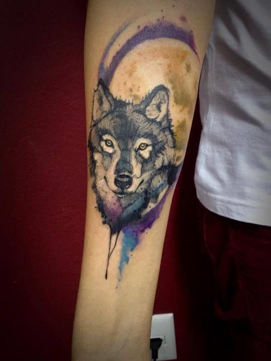 black and white Husky with purple and blue watercolor tattoo on the forerarm