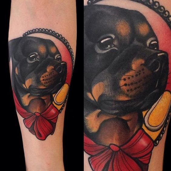 animated adorable face of Rottweiler inside frame with ribbon Tattoo on the forearm