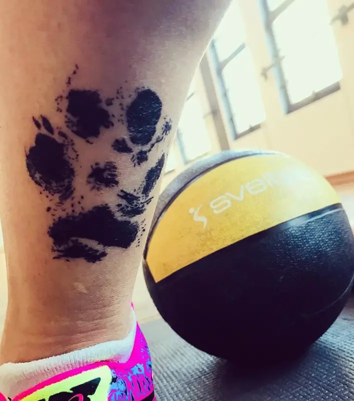 large paw print tattoo on the back of lower leg