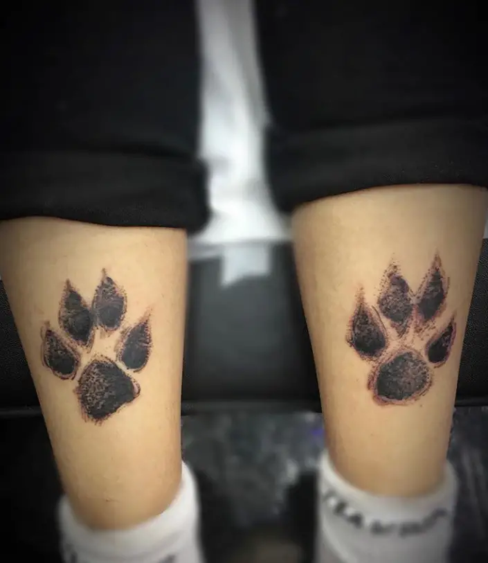 3D paw prints tattoo on both legs of the person