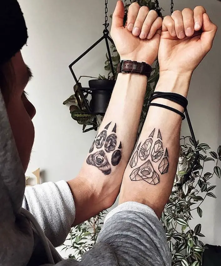 a man with paw prints on both his forearms in geometric and realistic design