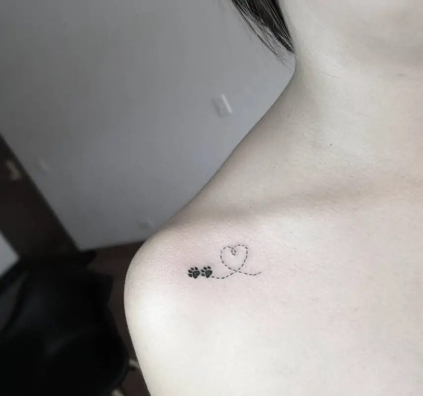 a heart line with two paw prints tattoo on the shoulder