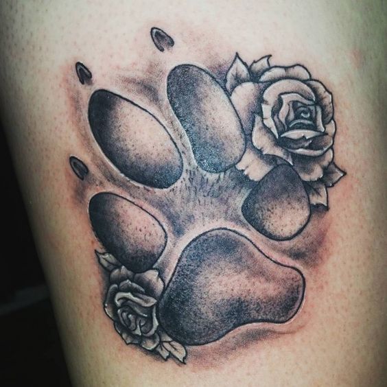 a large paw print with rose tattoo
