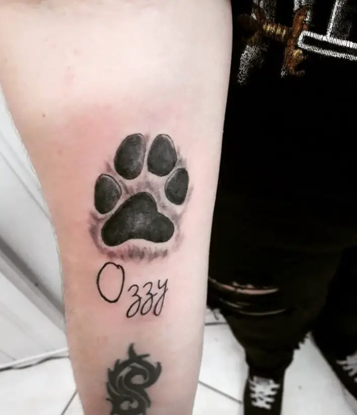 large 3D paw print with name Ozzy tattoo on the biceps