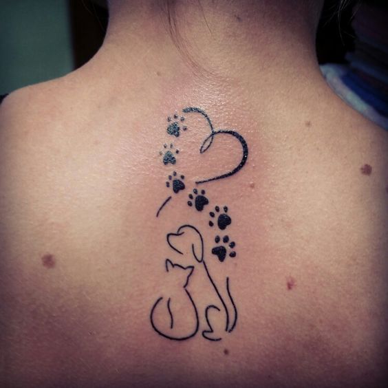 outline of a heart with paw print and a dog and cat tattoo on the back of a woman