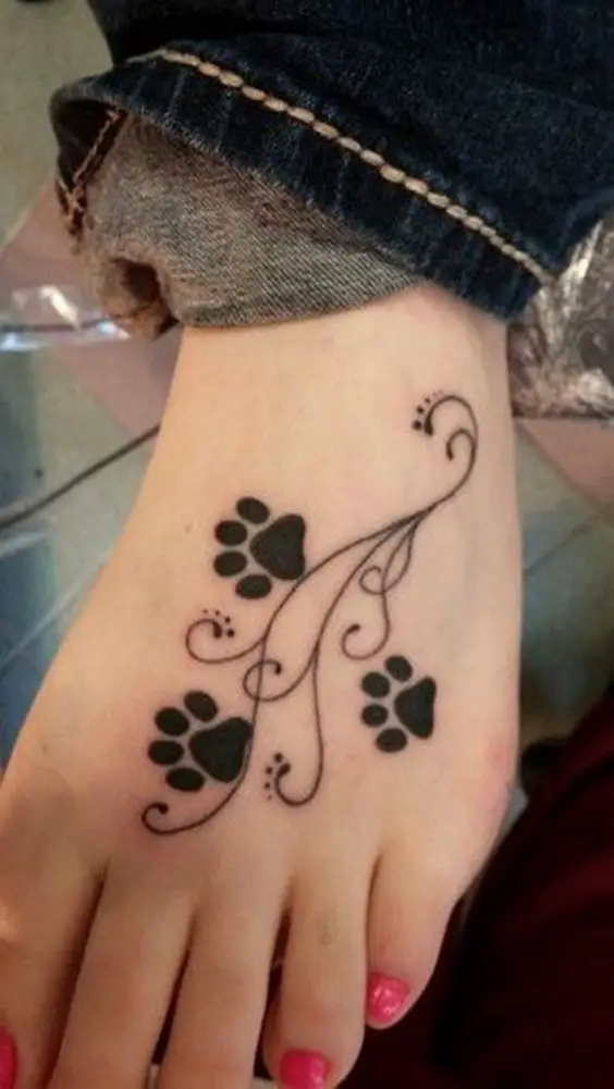 three paw prints tattoo on the foot