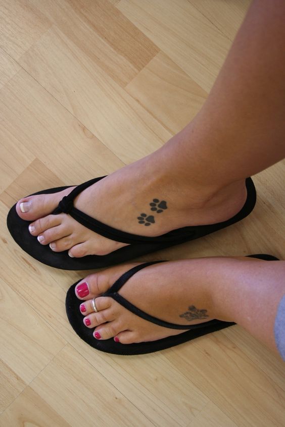 two paw prints tattoo on the feet