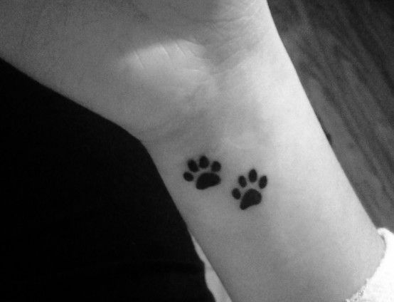 two paw print tattoo on the wrist of the woman