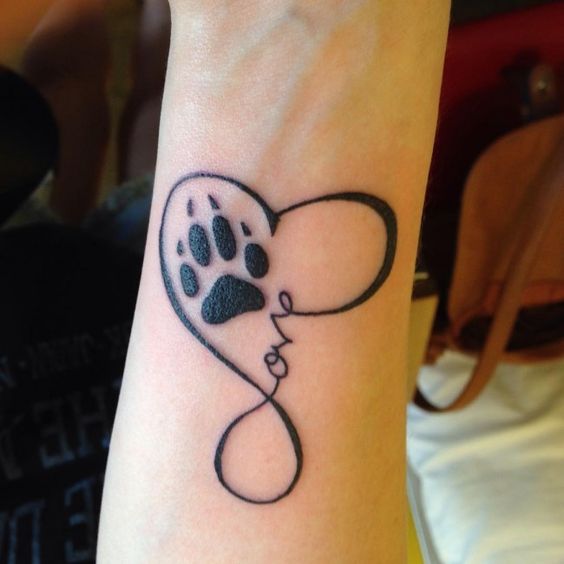 heart outline with a paw print tattoo on the wrist