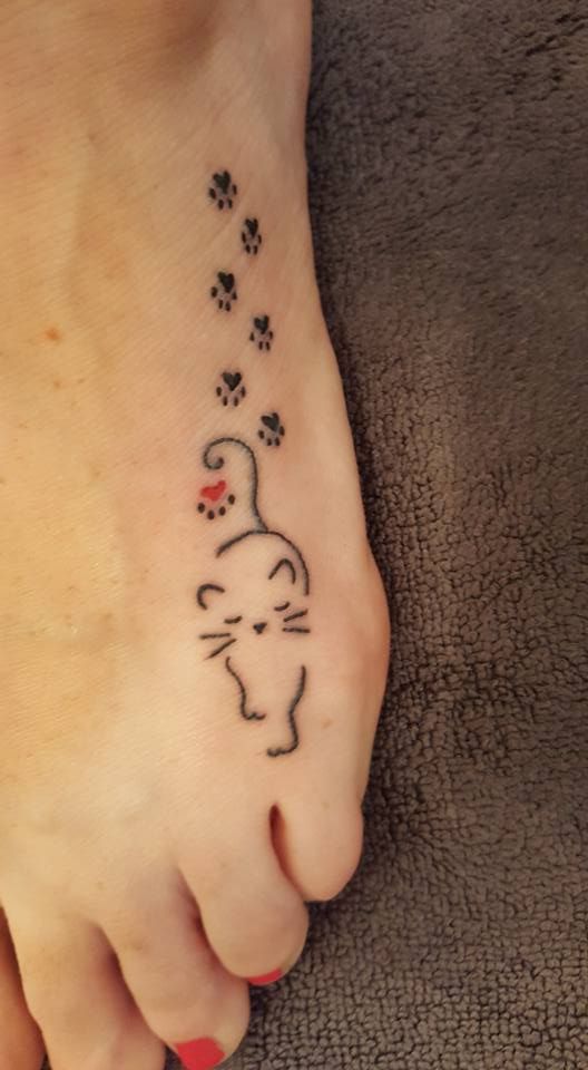six paw prints with an outline of a cat tattoo on the foot