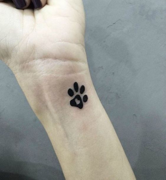 one paw print with heart inside tattoo on the wrist