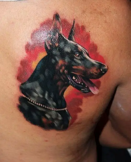 realistic sideview head of a Doberman with red smoky background tattoo on the back