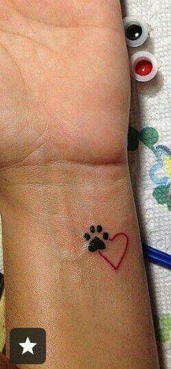 paw print with heart outline tattoo on the wrist