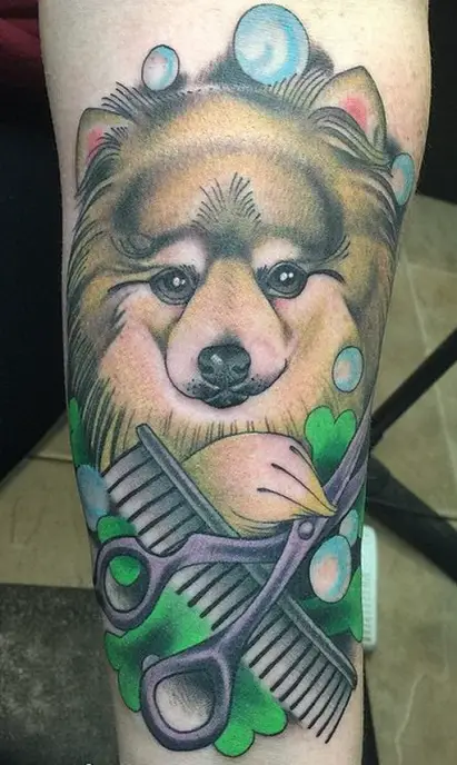 3D face of a Pomeranian holding scissors and comb with bubbles around it tattoo