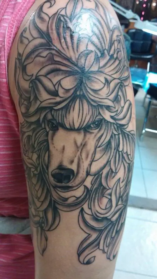 An outline Poodle Dog Tattoo on the shoulder of the man