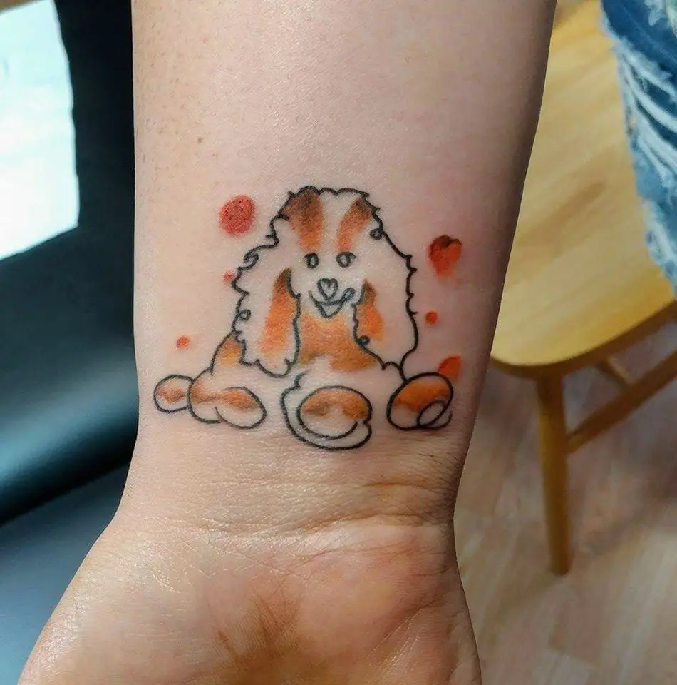 An outline of poodle with orange color tattoo on the wrist