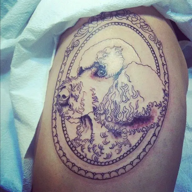 An outline sideview face of a Poodle Dog inside a vintage frame tattoo
