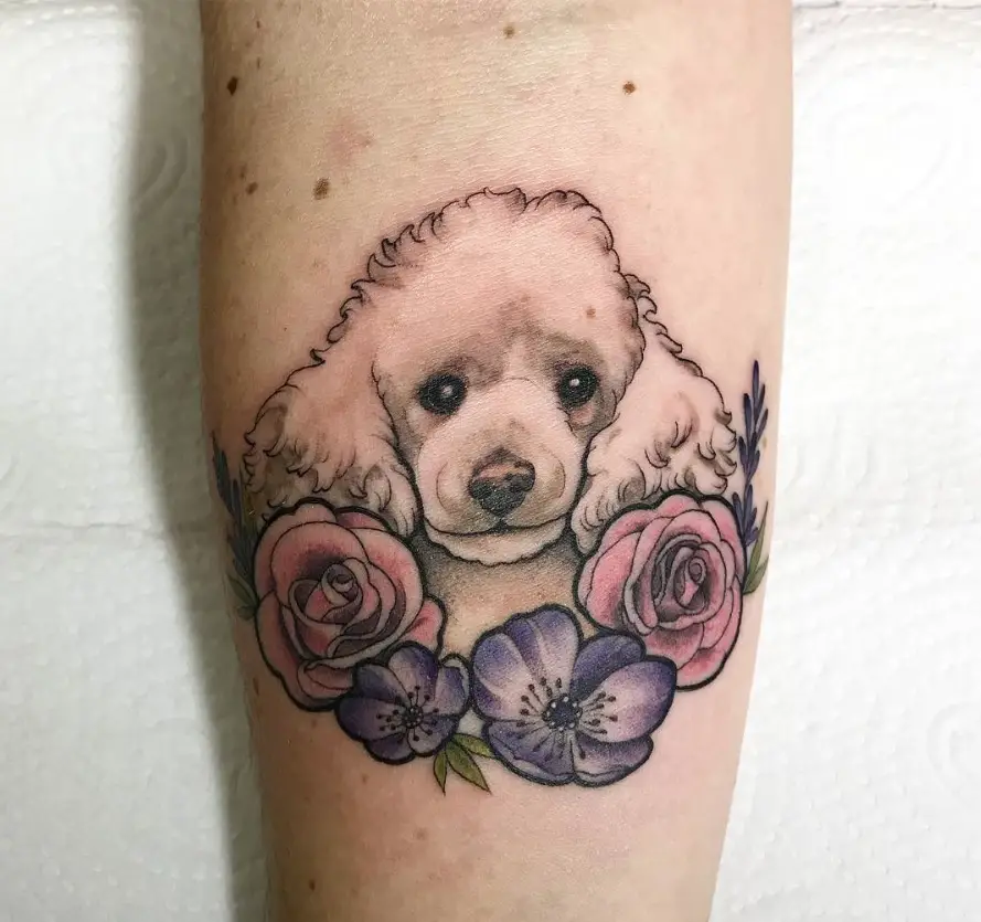 Poodle Dog with flowers tattoo on the forearm