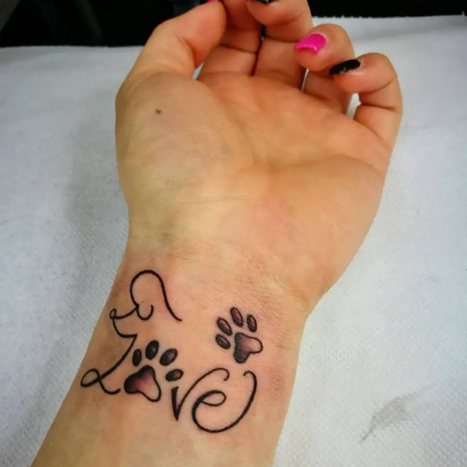 A -Love- tattoo with an outline of a Poodle and two paw prints on the wrist
