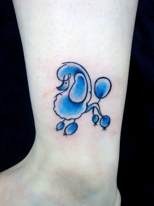 An outline of a Poodle with blue color tattoo on the leg