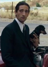 Adrien Brody carrying his Dachshund in his arm