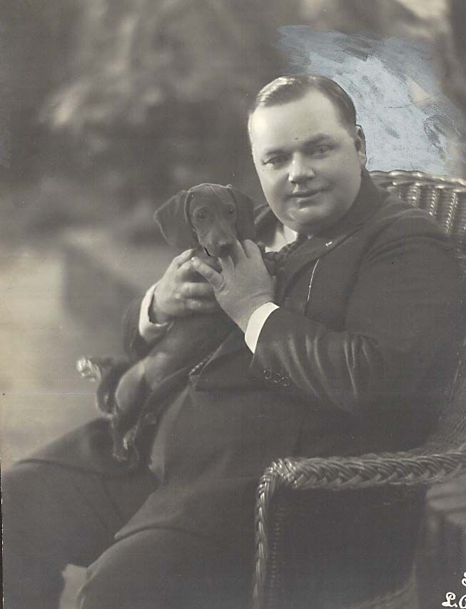 old photo of Fatty Arbuckle sitting on the chair with his Dachshund in his tummy