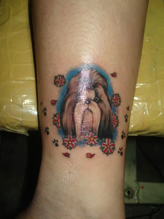 Shih Tzu with blue background and flowers tattoo on the leg