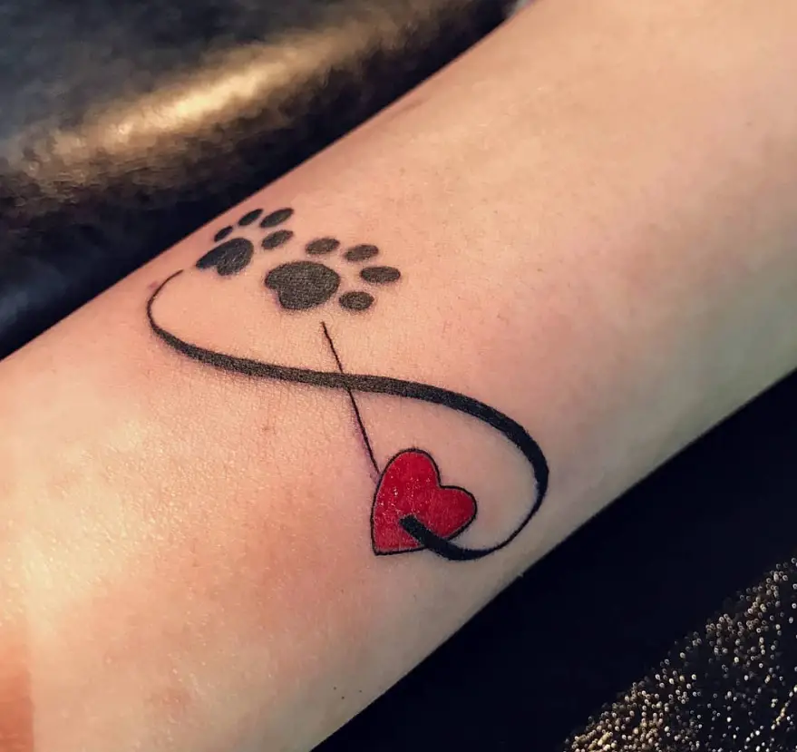 infinity sign with a paw print and red heart tattoo on the wrist