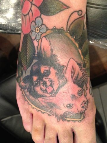 two Chihuahuas inside a heart shaped frame with leaves and flowers tattoo on the foot
