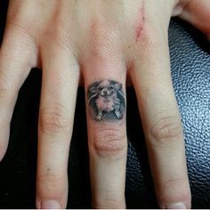 small sitting Chihuahua tattoo on the ring finger