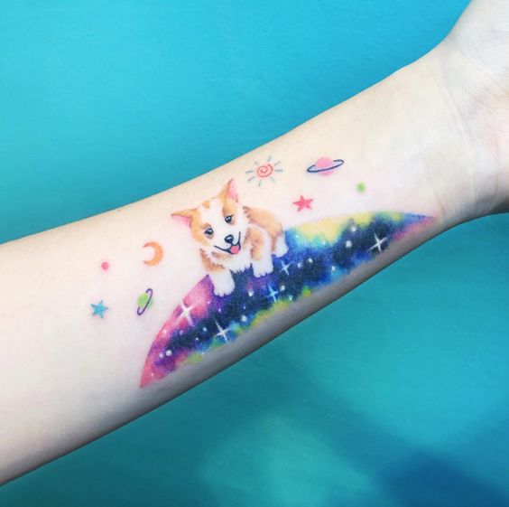 a corgi standing in the galaxy tattoo on the forearm