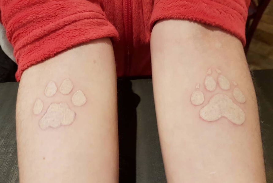 white paw print on both forearm of the woman