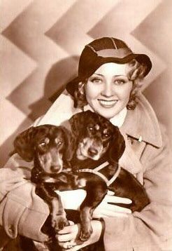 Joan Blondell with her two Dachshunds in her lap