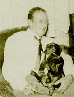 old photo of John Wayne with his Dachshund in his lap