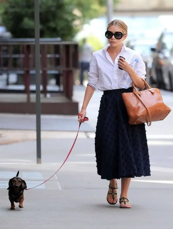 Mary Kate taking a walk in the street with her Dachshund